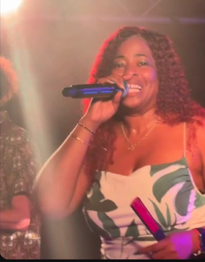 La chanteuse de SonGoson en concert, robe verte et blanche