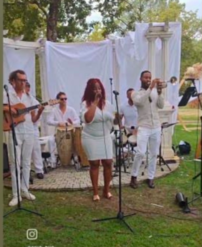 SonGoson tout en blanc en concert lors d'un mariage en extérieur